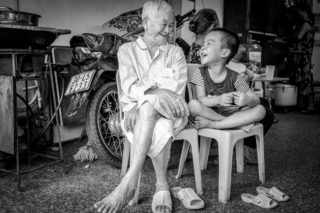 Black and White photo by Graeme Heckels Hanoi Street Photography Generations Grandfather Grandchild Family Portrait